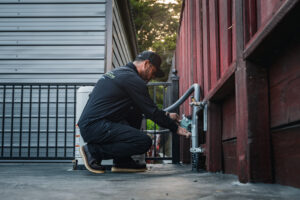 Technician inspecting outdoor gas line connection at residential property for safety maintenance.